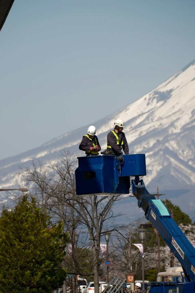 a-couple-of-men-standing-on-top-of-a-blue-lift-vssxhdezasw