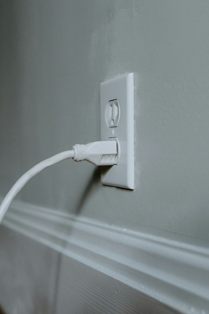 White plug plugged into an outlet on the wall